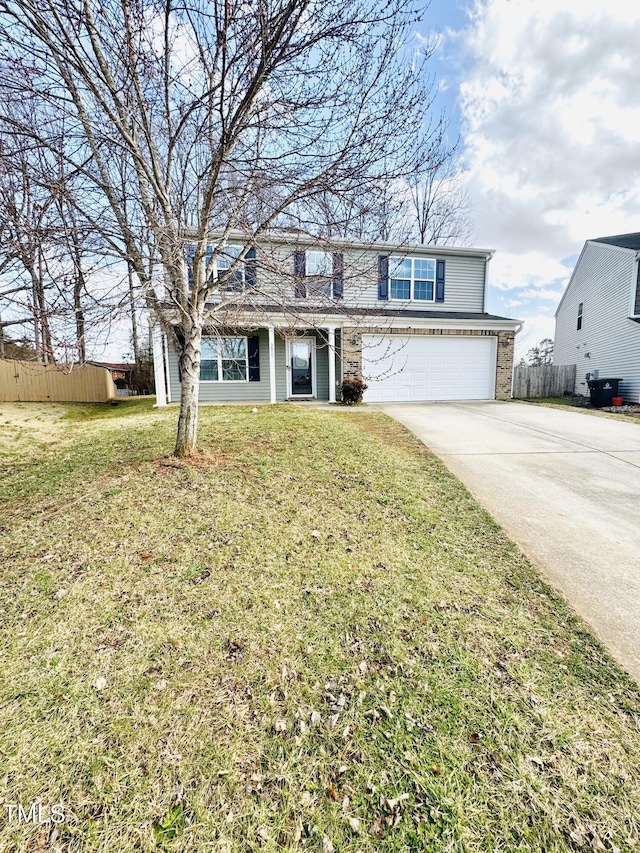 traditional-style house featuring a front yard, concrete driveway, fence, and an attached garage