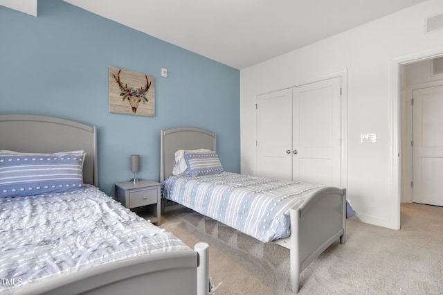 bedroom featuring light colored carpet and a closet