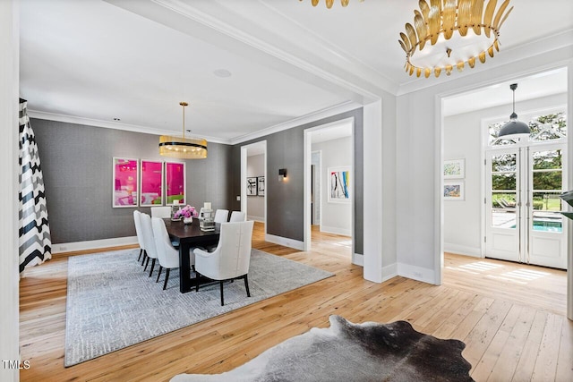 dining room with hardwood / wood-style flooring, crown molding, a chandelier, and french doors