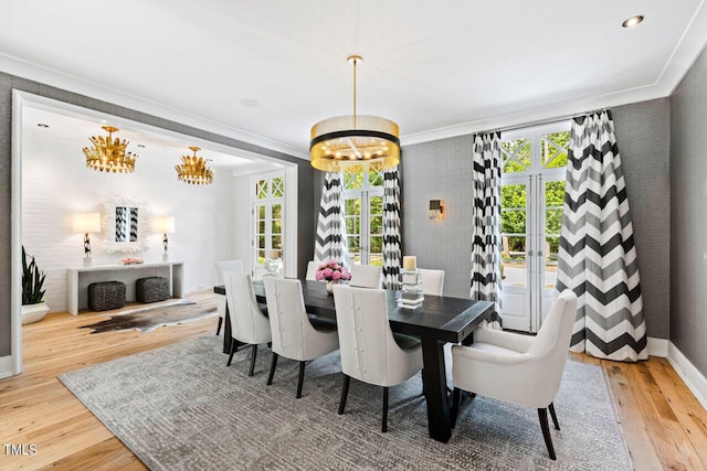 dining area featuring hardwood / wood-style flooring, ornamental molding, a notable chandelier, and french doors