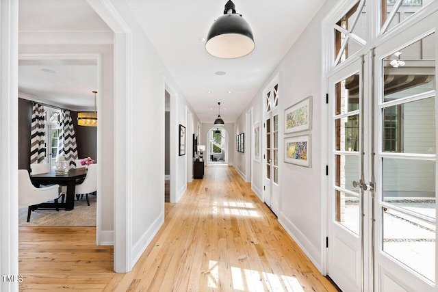 hall with light hardwood / wood-style flooring and french doors