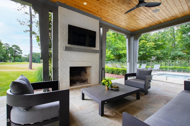 view of patio / terrace featuring an outdoor brick fireplace, a fenced in pool, and ceiling fan