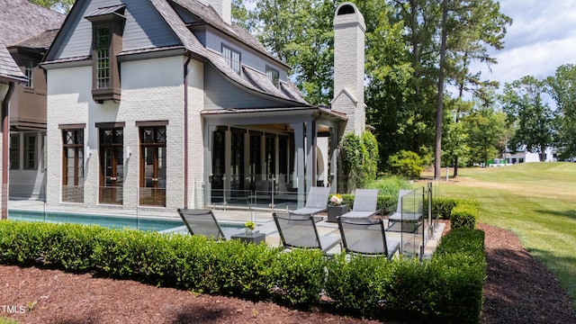 rear view of house with a patio area and a lawn