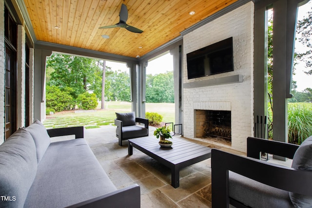 view of patio / terrace featuring ceiling fan and an outdoor living space with a fireplace