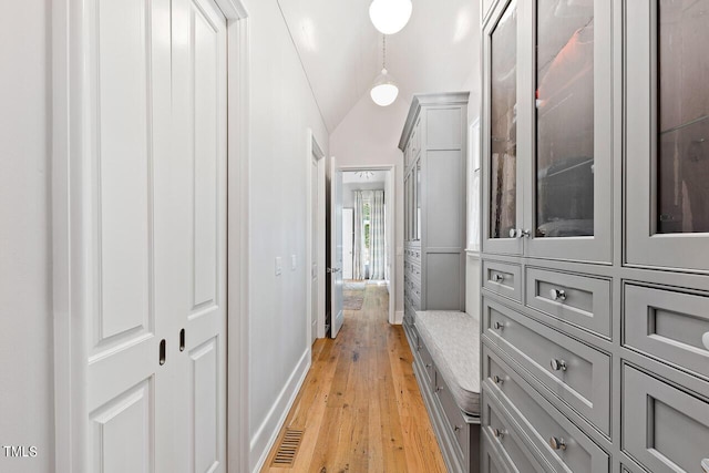 hall with vaulted ceiling and light hardwood / wood-style floors