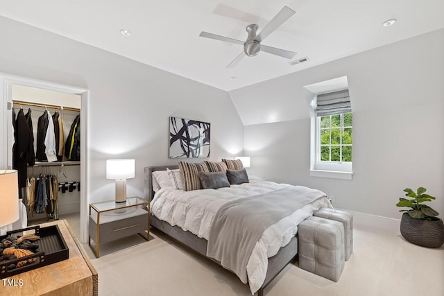 carpeted bedroom featuring lofted ceiling, a spacious closet, a closet, and ceiling fan