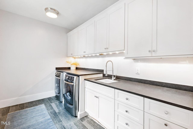 washroom featuring washer and dryer, sink, and cabinets