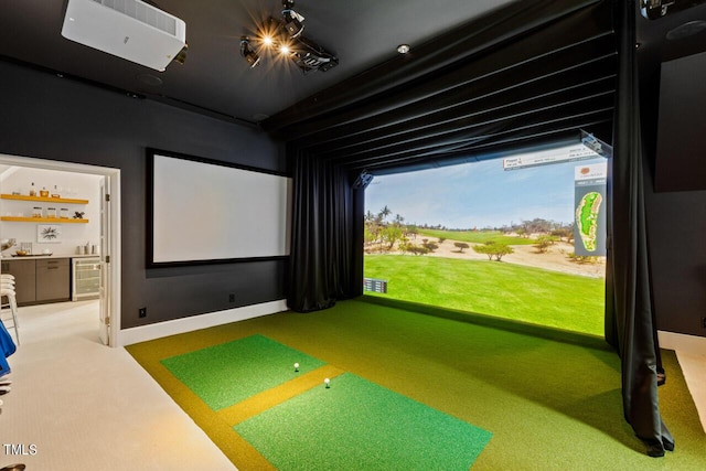 recreation room with golf simulator, beverage cooler, and carpet flooring