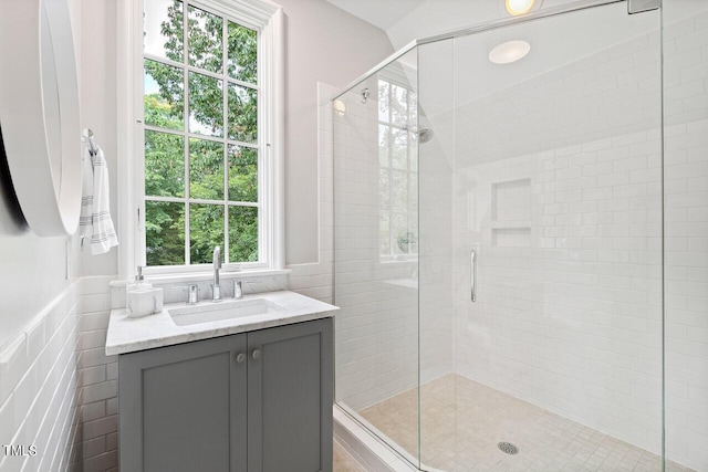 bathroom with sink, tile walls, and a shower with shower door