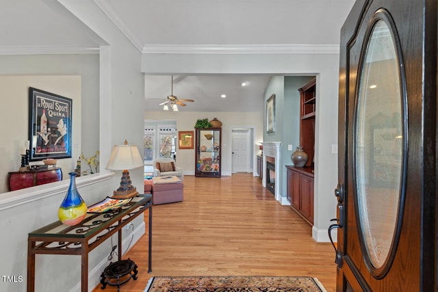 living room with crown molding, light hardwood / wood-style flooring, and ceiling fan