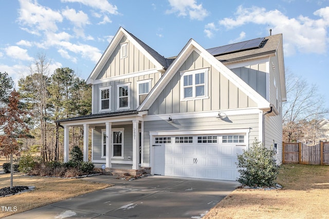 view of front of property with a garage, solar panels, and covered porch