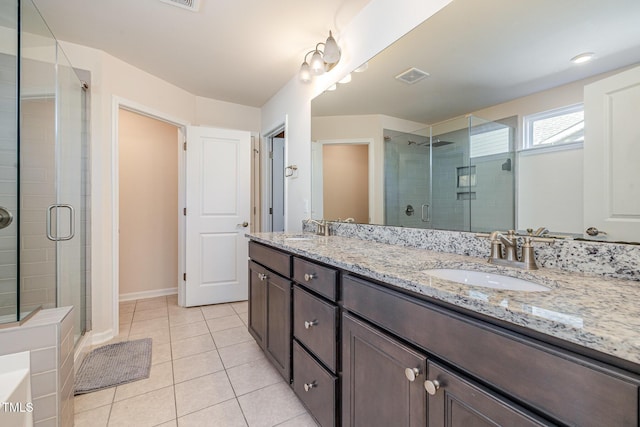 bathroom with walk in shower, vanity, and tile patterned flooring