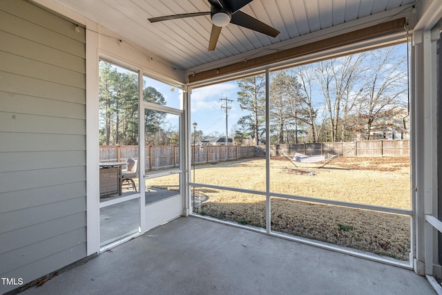 unfurnished sunroom with ceiling fan