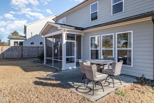 back of property with a sunroom and a patio area