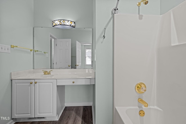 bathroom featuring vanity, wood-type flooring, and washtub / shower combination