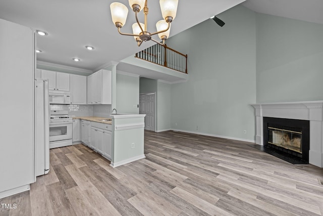 kitchen with tasteful backsplash, white cabinets, white appliances, and decorative light fixtures