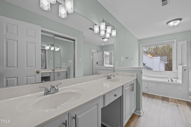 bathroom featuring vanity, hardwood / wood-style flooring, and separate shower and tub