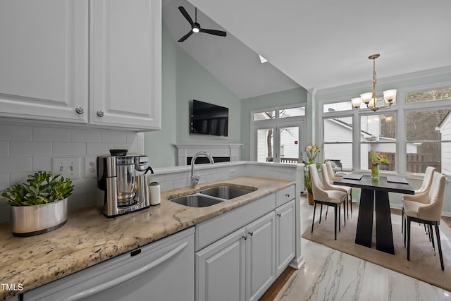 kitchen featuring sink, dishwasher, decorative backsplash, white cabinets, and decorative light fixtures