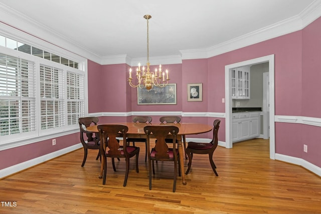 dining room featuring crown molding, a chandelier, and light hardwood / wood-style floors