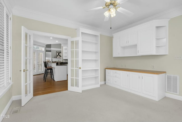 interior space with butcher block counters, white cabinetry, and french doors