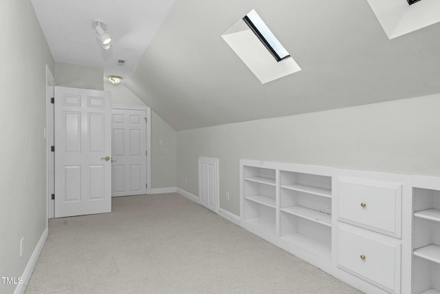 additional living space with built in features, lofted ceiling with skylight, and light colored carpet