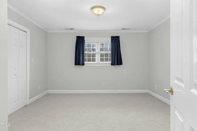 unfurnished room with ornamental molding and light colored carpet