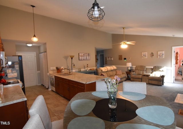 dining area with light tile patterned flooring, ceiling fan, high vaulted ceiling, and sink