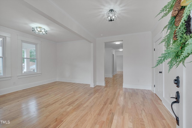 empty room with ornamental molding and light hardwood / wood-style flooring