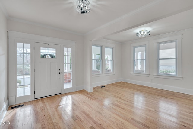 foyer entrance with ornamental molding and light wood-type flooring