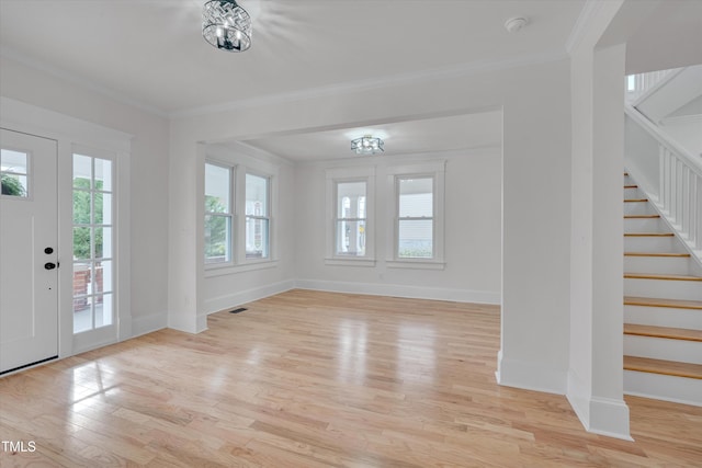 foyer entrance with crown molding and light hardwood / wood-style flooring