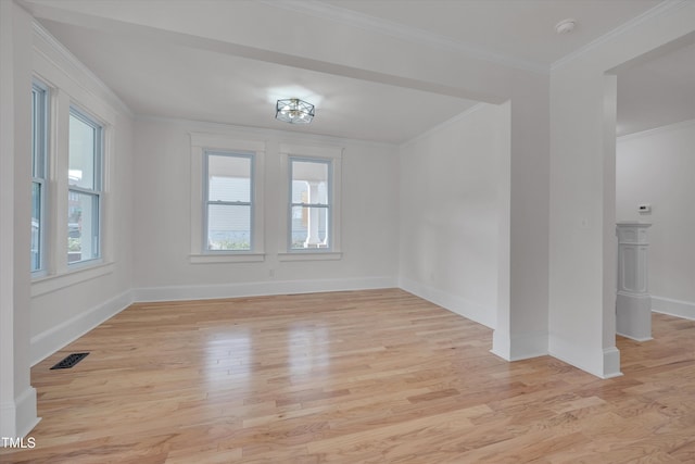 spare room featuring crown molding and light hardwood / wood-style flooring