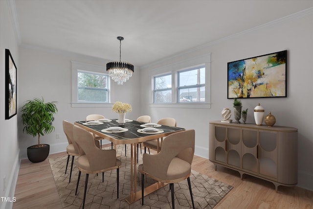 dining area with crown molding, a notable chandelier, and light wood-type flooring