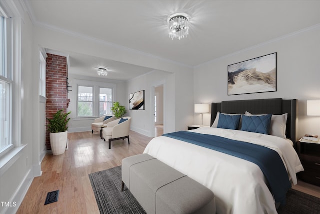 bedroom featuring ornamental molding and light wood-type flooring