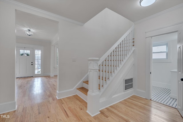 entrance foyer with crown molding and light hardwood / wood-style floors