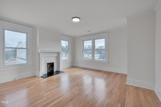 unfurnished living room with crown molding and light hardwood / wood-style floors