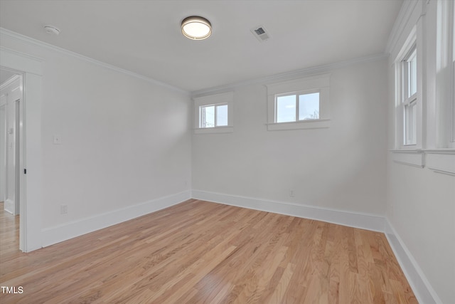 empty room with crown molding and light hardwood / wood-style flooring