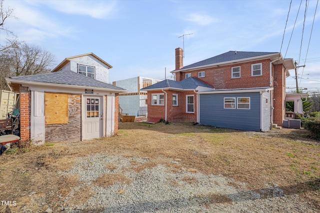 rear view of house featuring a yard and central AC