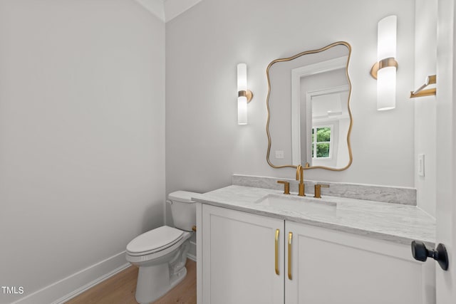 bathroom with hardwood / wood-style flooring, vanity, and toilet