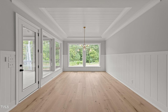 unfurnished sunroom with a raised ceiling and a chandelier