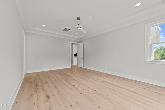 unfurnished room featuring ceiling fan, ornamental molding, a raised ceiling, and light hardwood / wood-style floors