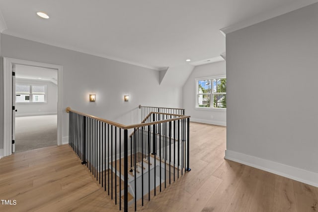 stairway with ornamental molding, a healthy amount of sunlight, and hardwood / wood-style floors