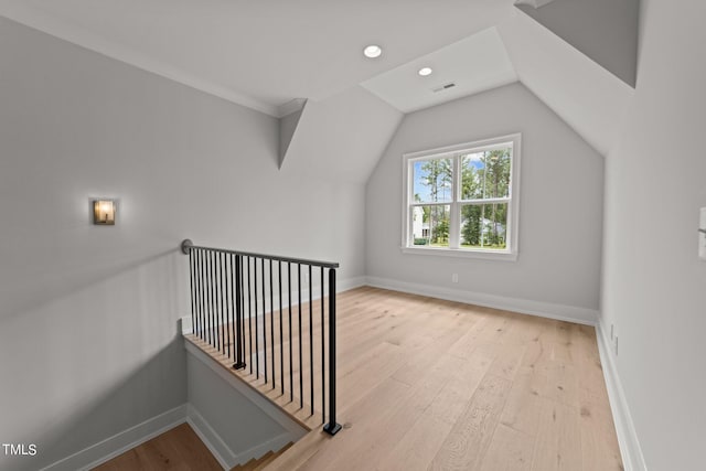 additional living space with light hardwood / wood-style flooring and vaulted ceiling