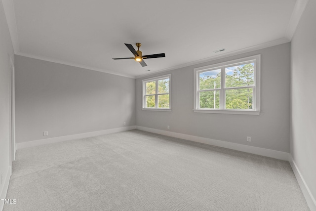 unfurnished room with a healthy amount of sunlight, light colored carpet, and ornamental molding