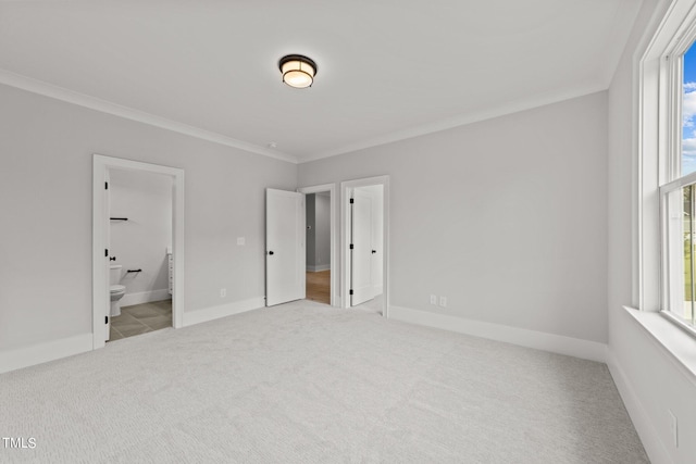 unfurnished bedroom with crown molding, connected bathroom, and light colored carpet