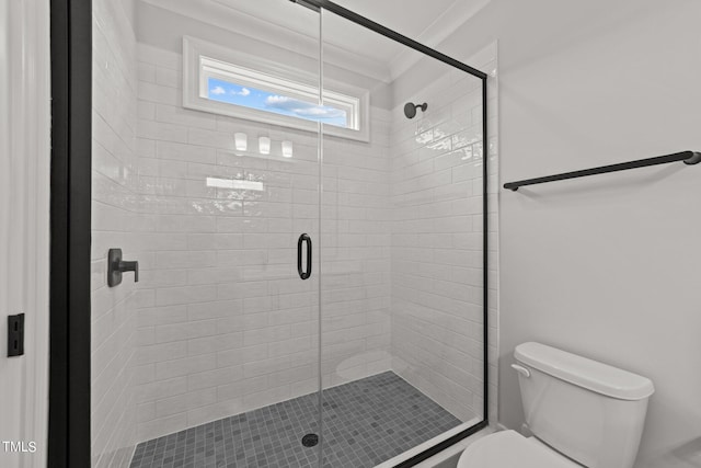 bathroom featuring a shower with shower door, ornamental molding, and toilet