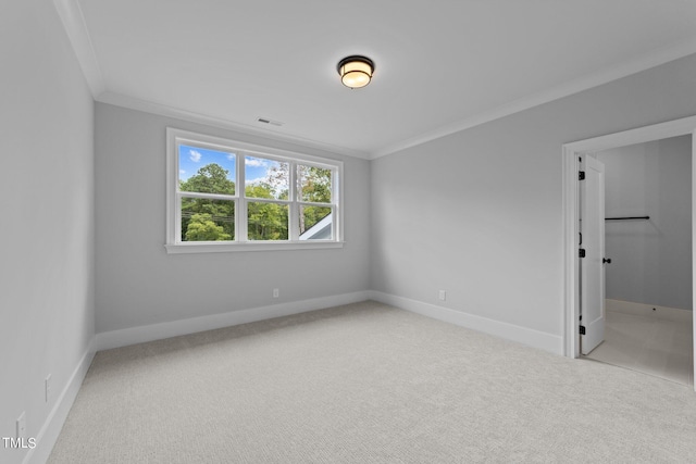 spare room with ornamental molding and light colored carpet