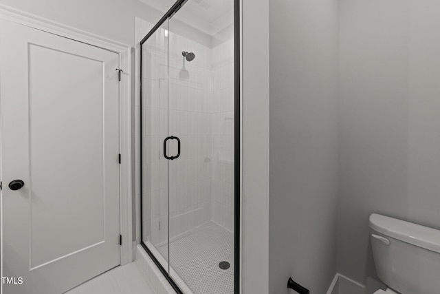 bathroom featuring an enclosed shower, tile patterned floors, and toilet