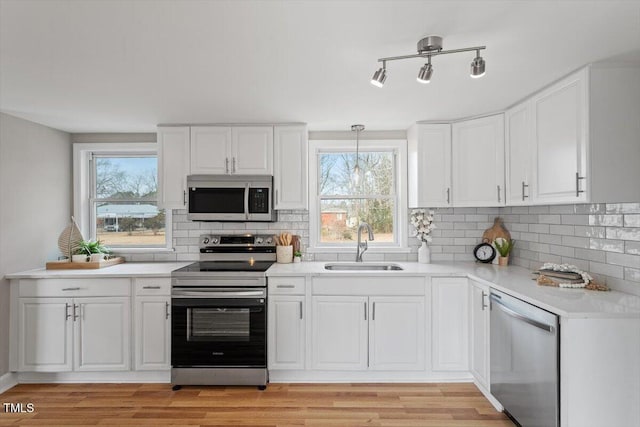 kitchen featuring pendant lighting, appliances with stainless steel finishes, and white cabinets