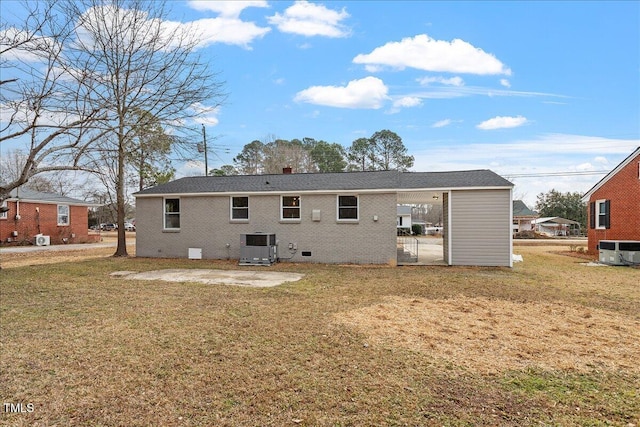 rear view of house featuring cooling unit, a patio area, and a lawn