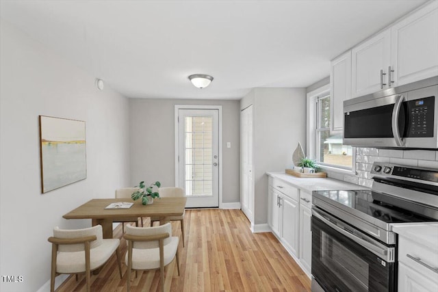 kitchen featuring stainless steel appliances, white cabinetry, and light wood-type flooring